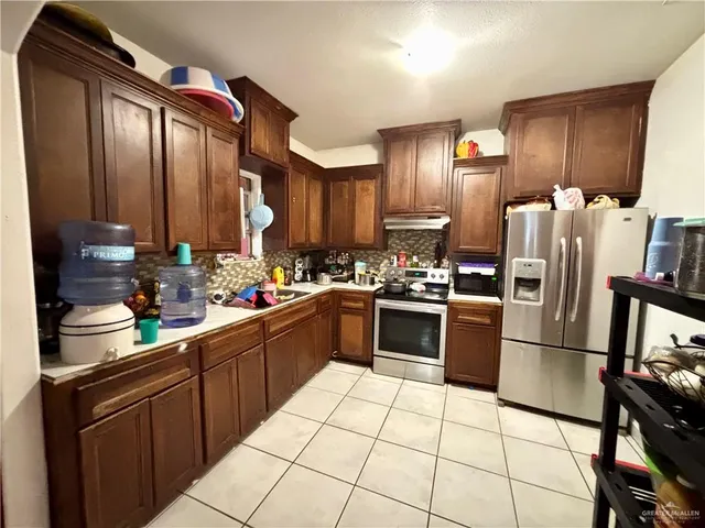 a kitchen with stainless steel appliances granite countertop a refrigerator sink and cabinets