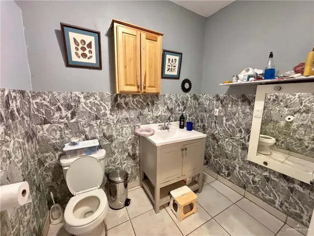 a bathroom with a toilet sink and mirror