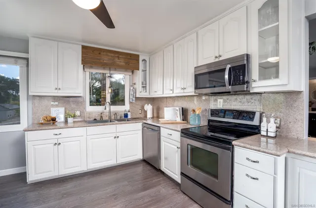 a kitchen with cabinets stainless steel appliances a sink and a microwave