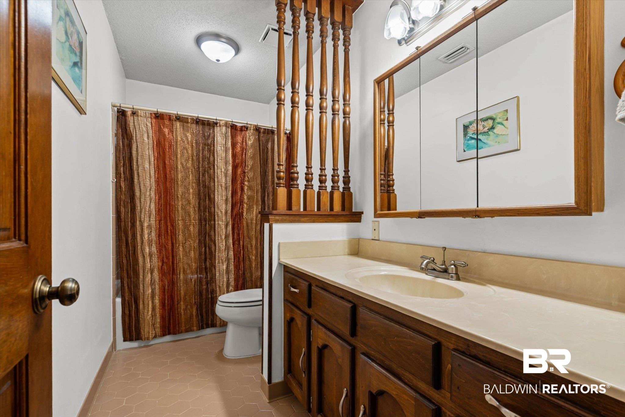 1900 Foxfire Road Mobile, AL 36618 - Photo 21 of 36 Bathroom with vanity, light tile patterned floors, and a textured ceiling