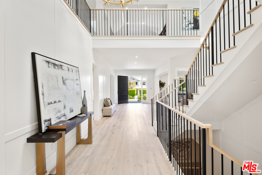 829 Greentree Road Pacific Palisades, CA 90402 - Photo 7 of 50 a view of staircase with wooden floor and a chandelier
