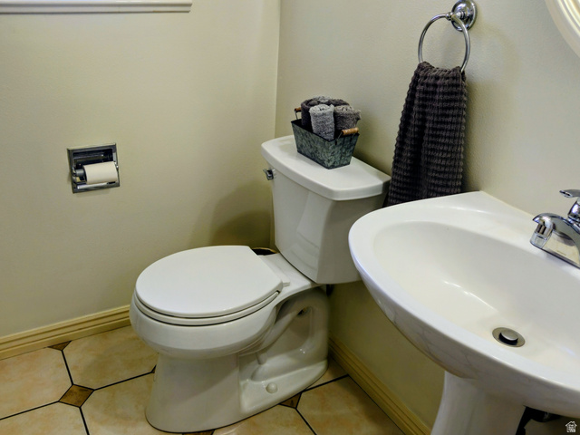 802 East 3200 Road North Preston, ID 83263 - Photo 48 of 59 Pedestal sink with chrome faucet, white toilet, wall-mounted towel ring, inset toilet paper holder, and geometric floor tiling