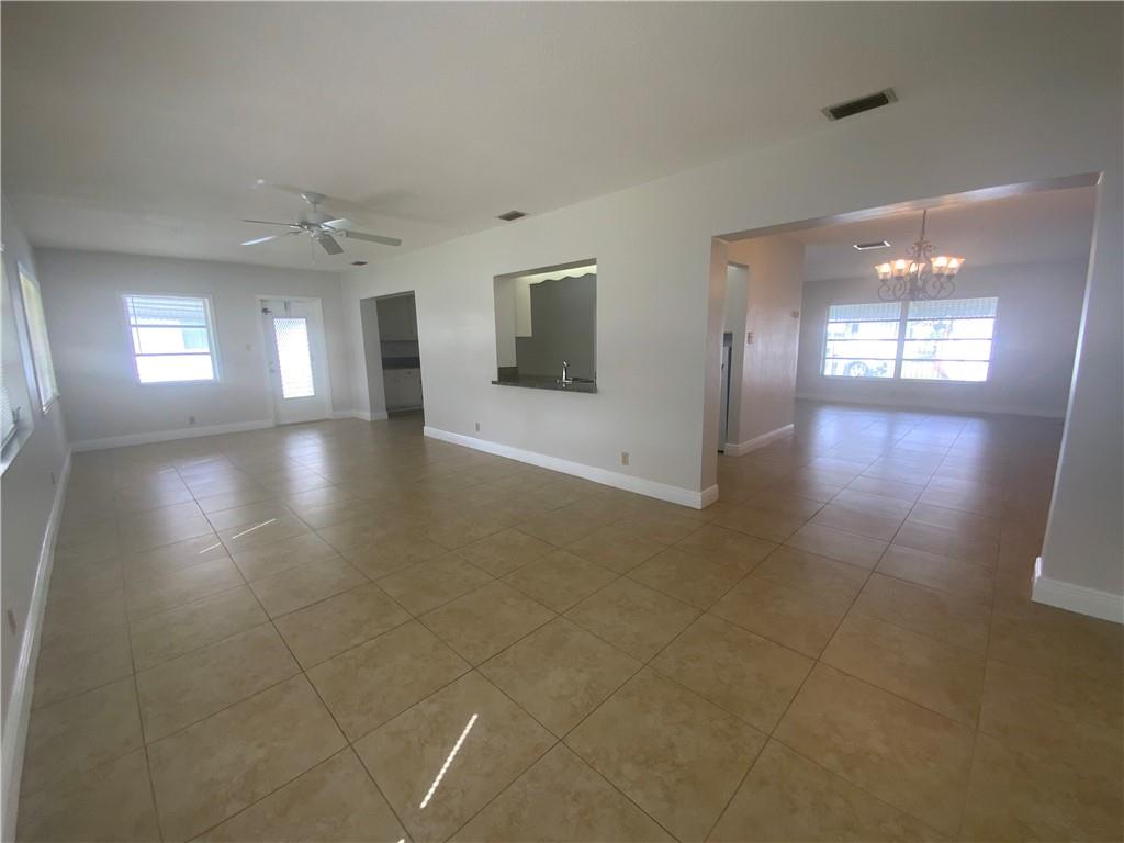 7104 Northwest 70th Street Tamarac, FL 33321 - Photo 11 of 30 an empty room with wooden floor and windows