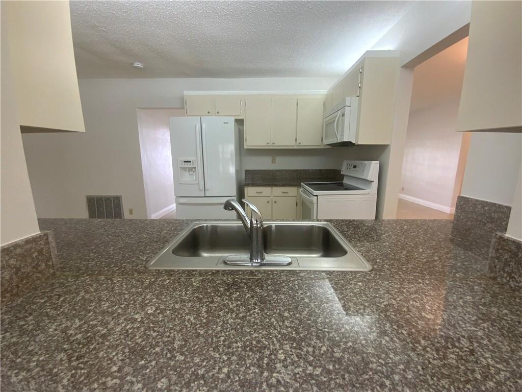 7104 Northwest 70th Street Tamarac, FL 33321 - Photo 13 of 30 a kitchen with kitchen island a sink stove and refrigerator