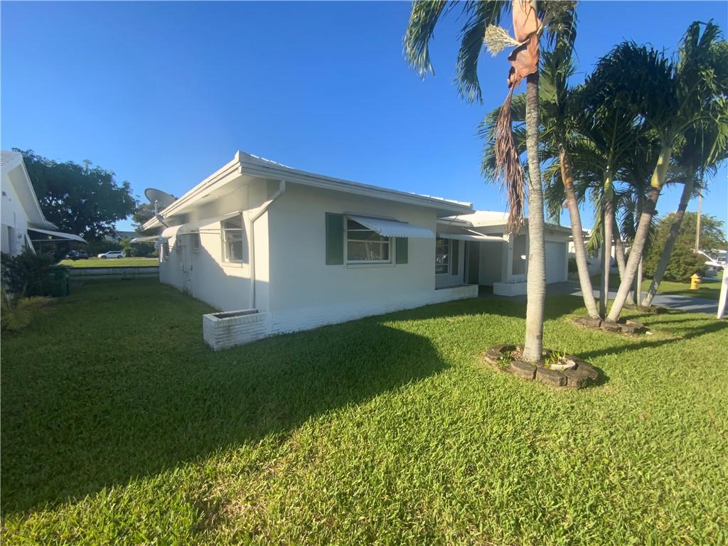 7104 Northwest 70th Street Tamarac, FL 33321 - Photo 2 of 30 a front view of a house with garden