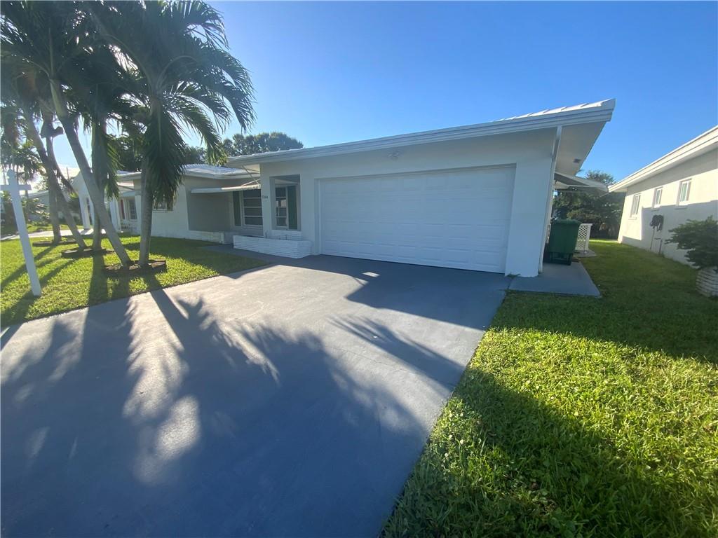 7104 Northwest 70th Street Tamarac, FL 33321 - Photo 3 of 30 a front view of a house with garden