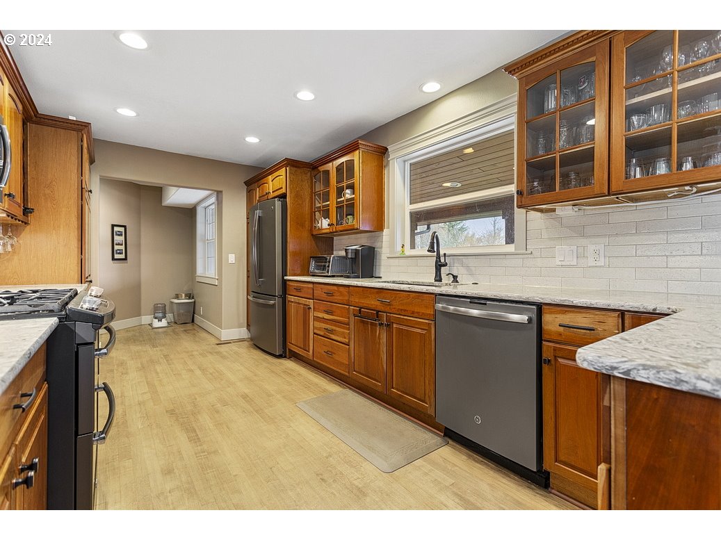 5360 Southeast Chase Road Gresham, OR 97080 - Photo 5 of 48 a kitchen with stainless steel appliances granite countertop a sink and wooden cabinets
