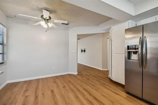 an empty room with wooden floor chandelier fan and closet area