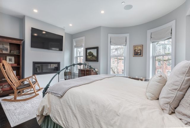 a bedroom with a bed a flat screen tv and dresser