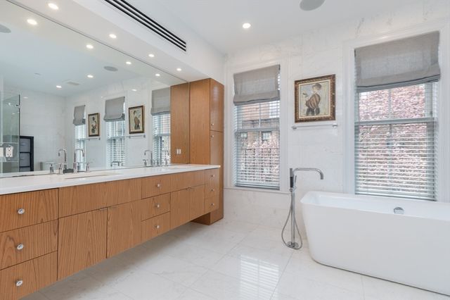 a spacious bathroom with a granite countertop tub sink shower and mirror