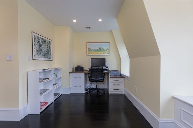 a view of a hallway with workspace and wooden floor