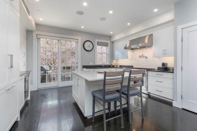 a kitchen with granite countertop a stove a table and chairs in it