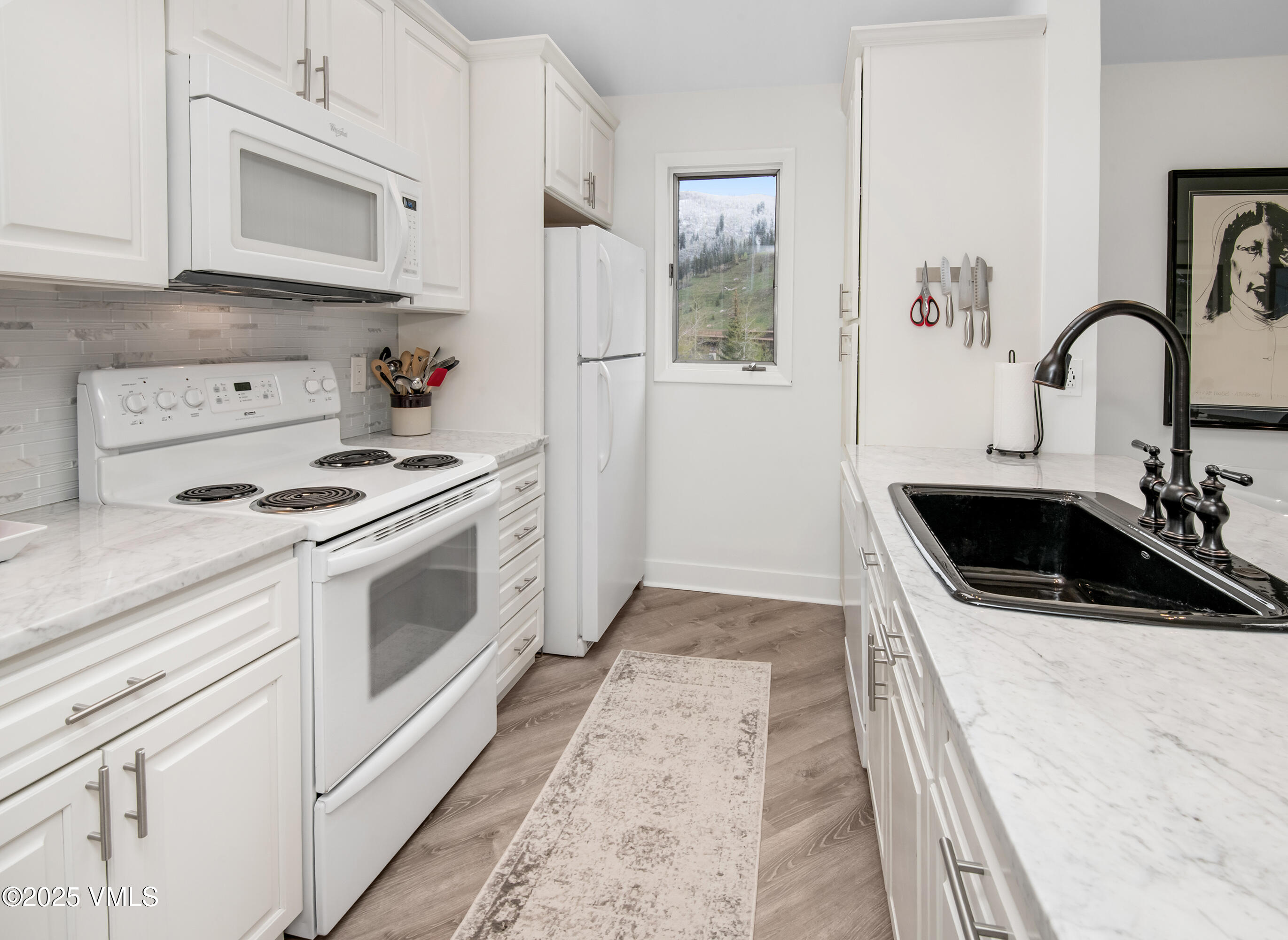 4480 Timber Falls Court, Unit 1507 Vail, CO 81657 - Photo 11 of 29 a kitchen with white cabinets and white appliances