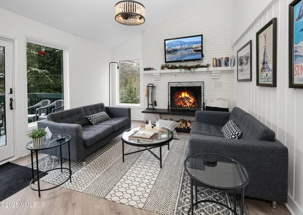 a living room with furniture a flat screen tv and a fireplace