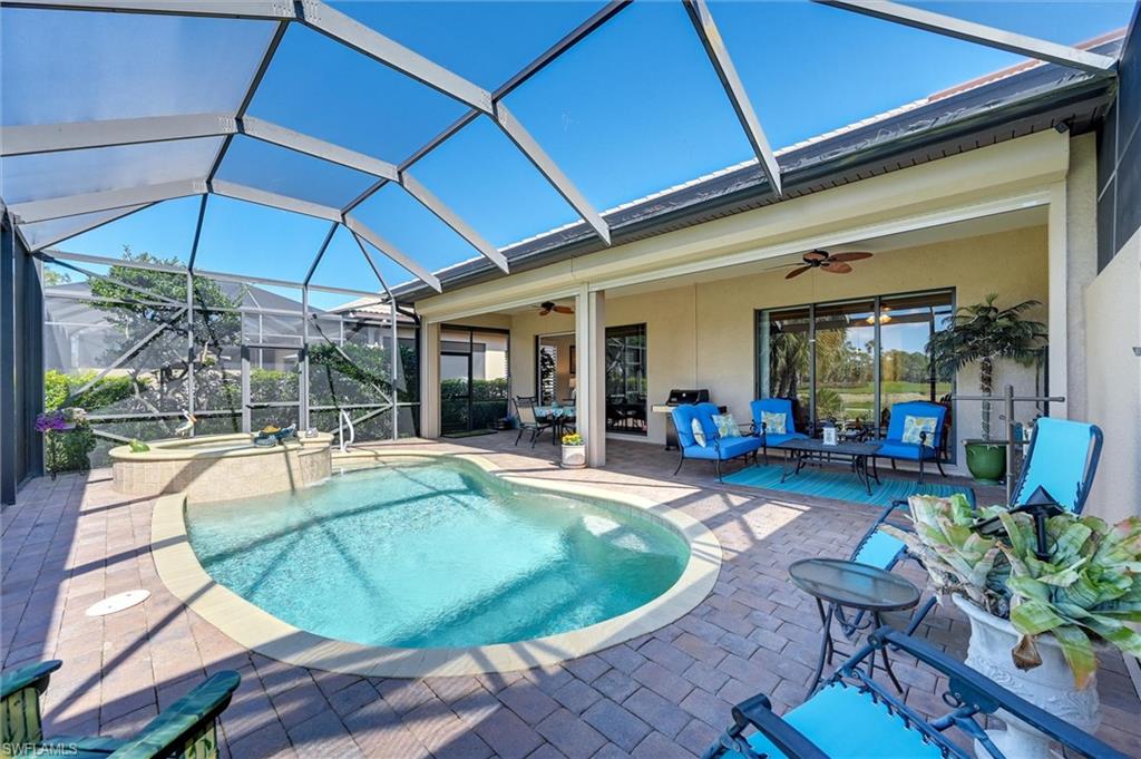 7587 Moorgate Point Way Naples, FL 34113 - Photo 11 of 47 a view of a swimming pool with chairs in patio
