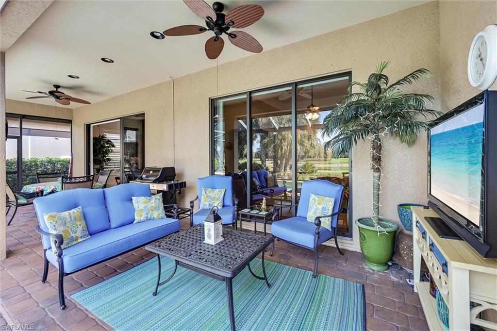 7587 Moorgate Point Way Naples, FL 34113 - Photo 13 of 47 a living room with furniture and a flat screen tv