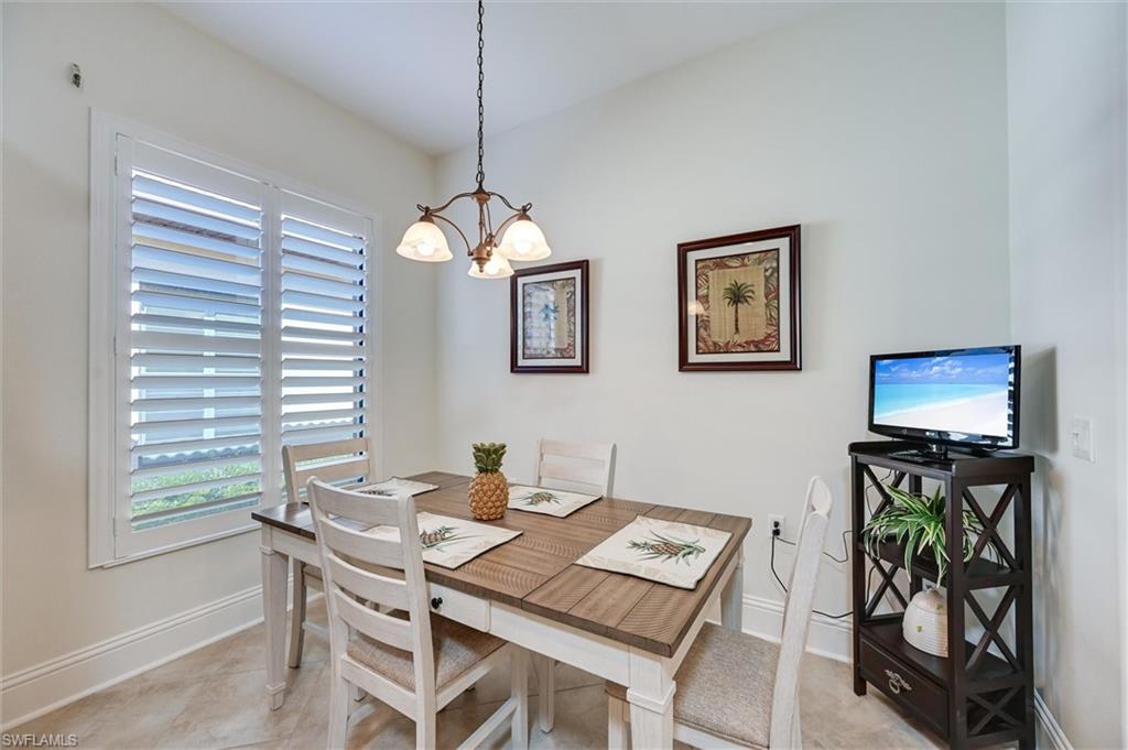 7587 Moorgate Point Way Naples, FL 34113 - Photo 23 of 47 a view of a dining room with furniture a chandelier and wooden floor