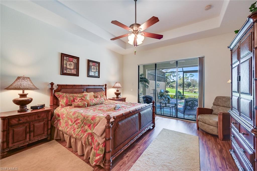 7587 Moorgate Point Way Naples, FL 34113 - Photo 29 of 47 a bedroom with a bed and a chandelier