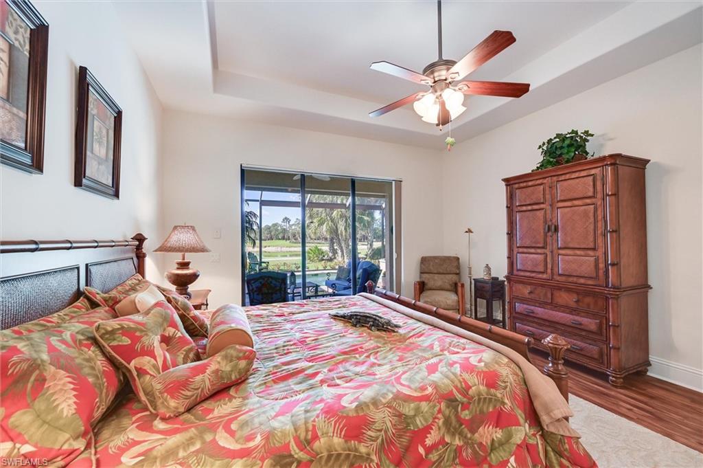 7587 Moorgate Point Way Naples, FL 34113 - Photo 31 of 47 a bedroom with a large bed and a chandelier