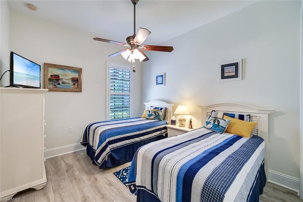 7587 Moorgate Point Way Naples, FL 34113 - Photo 35 of 47 a bedroom with two beds and a chandelier
