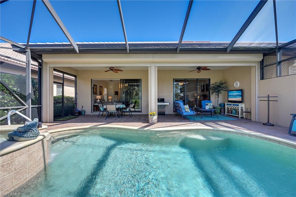 7587 Moorgate Point Way Naples, FL 34113 - Photo 10 of 47 a view of a patio with table and chairs under an umbrella