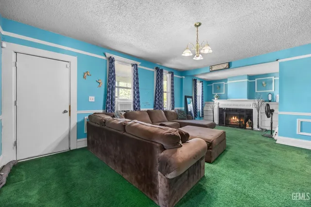 a living room with furniture a fireplace and a chandelier