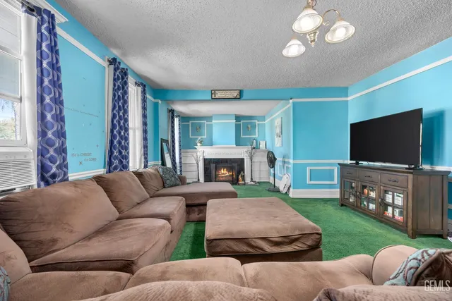 a living room with furniture a flat screen tv and a large window