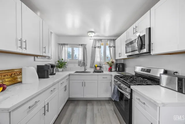 a kitchen with cabinets stainless steel appliances a sink and a counter top space