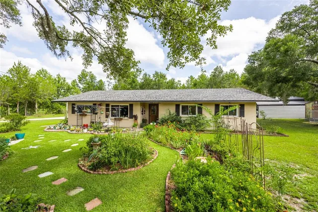 a front view of a house with yard and green space