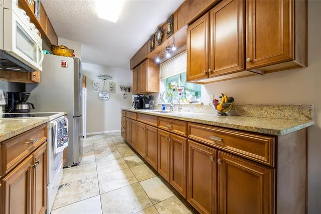 a kitchen with stainless steel appliances granite countertop a sink stove and cabinets