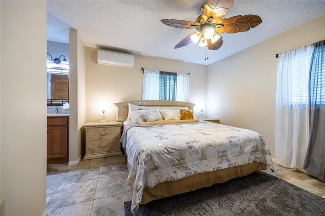 a bedroom with a bed a chandelier and dresser