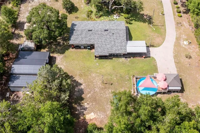 an aerial view of a house with a garden and lake view