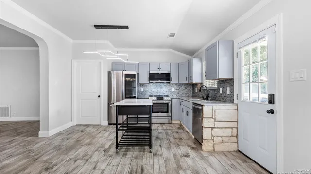 a kitchen with white cabinets and stainless steel appliances