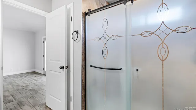 a bathroom with a glass shower door and a shower
