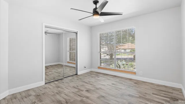an empty room with wooden floor and windows
