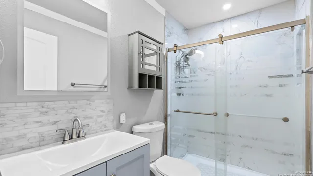 a bathroom with a sink toilet and shower