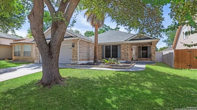 a view of a patio with table and chairs potted plants and large tree
