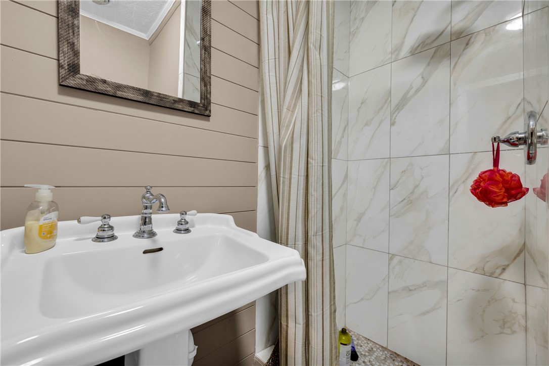 3030 Smith McGee Road Iva, SC 29655 - Photo 38 of 46 A well-appointed bathroom with a classic pedestal sink and elegant tiled shower.