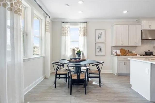 a kitchen with stainless steel appliances granite countertop a refrigerator a sink dishwasher a stove and white cabinets with wooden floor