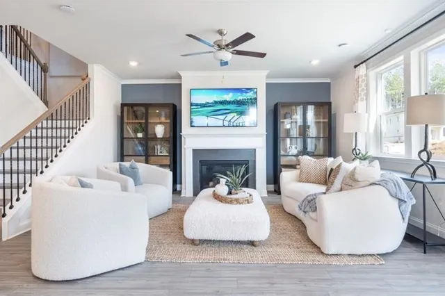a living room with furniture a fireplace and a ceiling fan