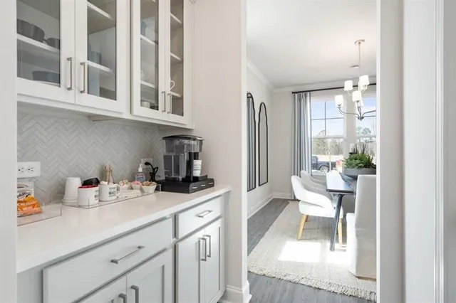 a kitchen with stainless steel appliances granite countertop white cabinets a sink and chairs