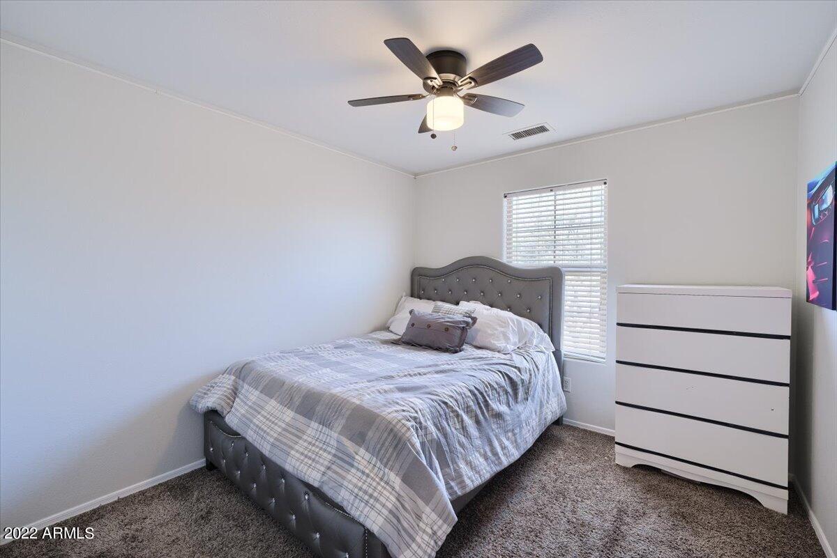 3889 East Timberline Road Gilbert, AZ 85297 - Photo 12 of 25 a bedroom with a bed and a ceiling fan