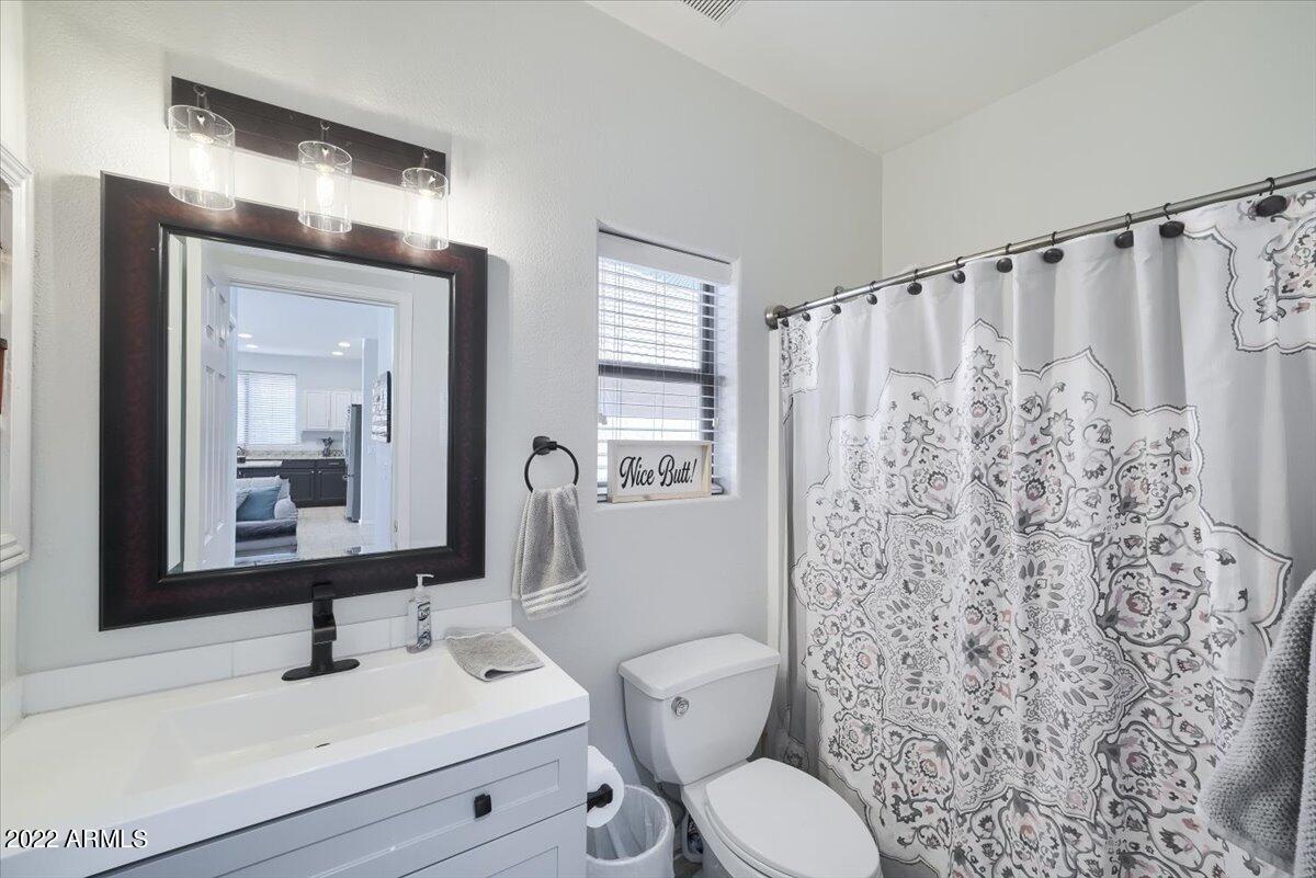 3889 East Timberline Road Gilbert, AZ 85297 - Photo 17 of 25 a bathroom with a toilet sink and mirror