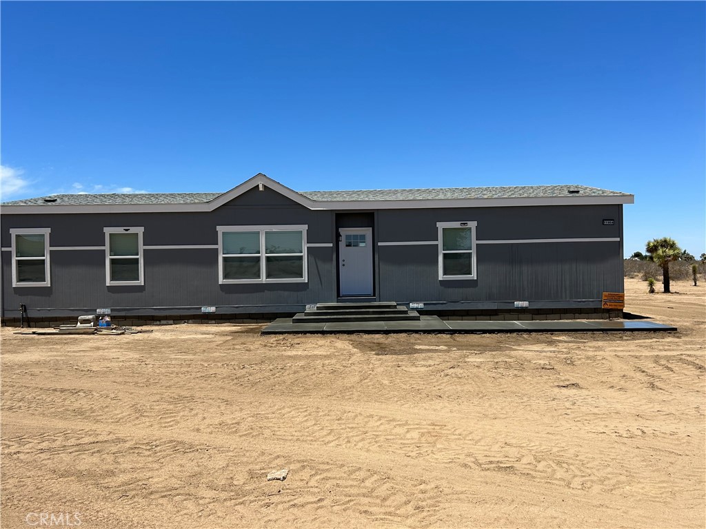11954 Wilson Ranch Road Phelan, CA 92371 - Photo 1 of 1 a front view of a house with a yard