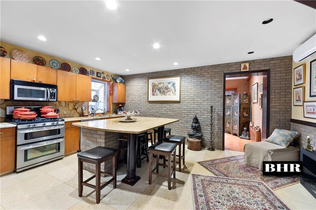 179 Norfolk Street Brooklyn, NY 11235 - Photo 7 of 31 a kitchen with stainless steel appliances granite countertop a stove a sink dishwasher and a dining table with wooden floor