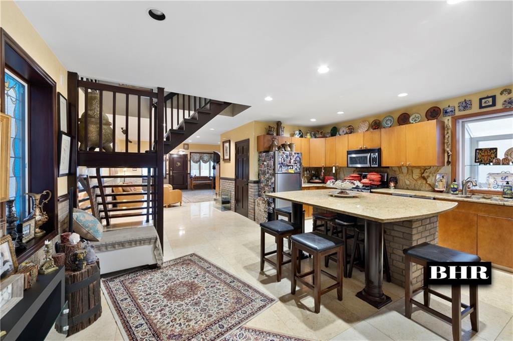 179 Norfolk Street Brooklyn, NY 11235 - Photo 8 of 31 a kitchen with stainless steel appliances kitchen island granite countertop a table chairs and a refrigerator