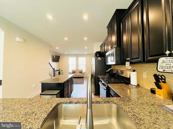 a kitchen with stainless steel appliances granite countertop a sink stove and cabinets