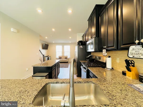 a kitchen with stainless steel appliances granite countertop a sink a stove and a refrigerator