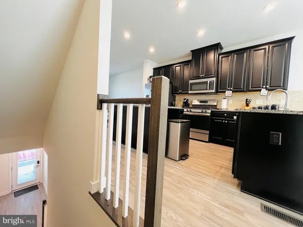 a kitchen with stainless steel appliances granite countertop a refrigerator and a stove top oven