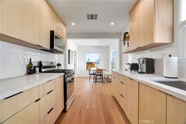 a kitchen with stainless steel appliances granite countertop sink stove top oven and cabinets